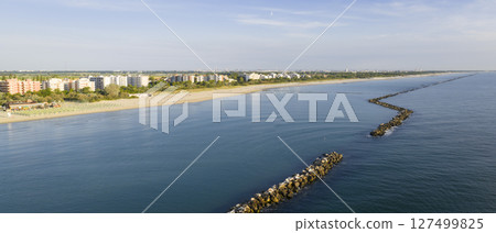 Coastline of italian sandy beaches with umbrellas and gazebos at morning Coastline of italian sandy beaches with umbrellas and gazebos at morning 127499825