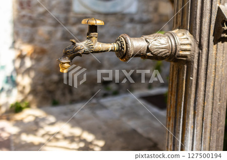 Close-up of ornate bronze water tap. Vintage craftsmanship, historical design, and functional detail. 127500194
