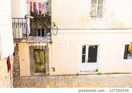 Colorful laundry above vintage doorway. Everyday charm, historical texture, and Mediterranean lifestyle. 127500206