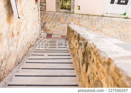 Stone staircase leading to old town street. Urban navigation, architectural texture, and Mediterranean atmosphere. 127500207