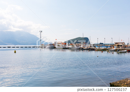 Coastal harbor with anchored boats and island view in the background. Peaceful seascape, marine lifestyle, and travel destination concept. 127500237