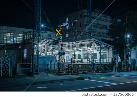 Pedestrians crossing the railroad crossing at Odakyu Sagamihara Station at night 127500806