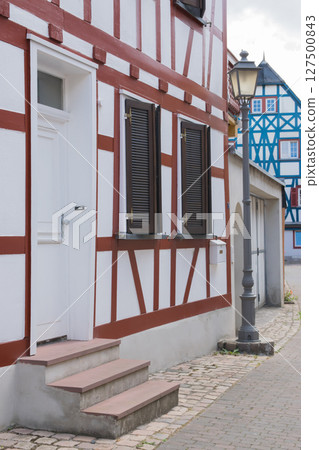 Door, ladder and windows of old traditional house on the city street in Germany. Door, ladder and windows of old traditional house on the city street in Germany. 127500843