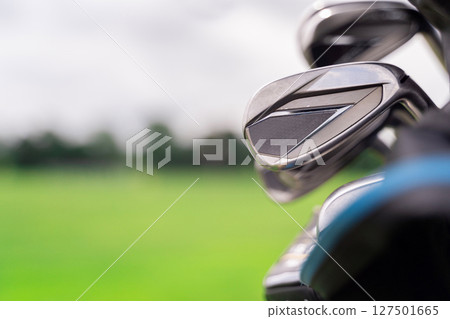A CloseUp View of Golf Clubs Positioned on a Bright Sunny Day at the Golf Course A CloseUp View of Golf Clubs Positioned on a Bright Sunny Day at the Golf Course 127501665