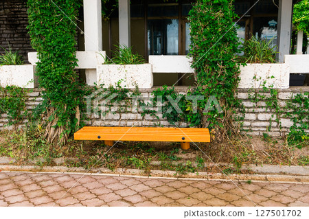 Green wooden bench in sunny park. Public space, relaxation area, and outdoor urban furniture Green wooden bench in sunny park. Public space, relaxation area, and outdoor urban furniture 127501702