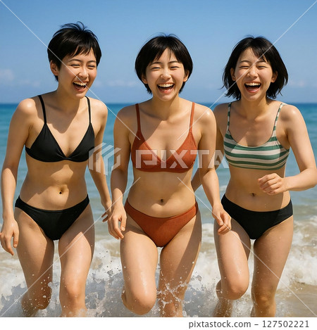 三位身穿泳衣的短髮女子在海浪中嬉戲玩耍的場景 127502221