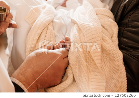 Tender Father's Love: New Baby Foot with Leather Jacket, Baptism Ritual, Cream Knit Blanket, Symbolic Family Moment, Warm Color Tone Tender Father's Love: New Baby Foot with Leather Jacket, Baptism Ritual, Cream Knit Blanket, Symbolic Family Moment, Warm Color Tone 127502260