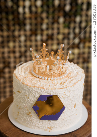 Golden Crown Adorned Peach Birthday Cake with Gold Accents on Wooden Stand. Regal Celebration Dessert Decor Golden Crown Adorned Peach Birthday Cake with Gold Accents on Wooden Stand. Regal Celebration Dessert Decor 127502319