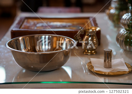 Christian Baptism Preparation Table Scene: Silver Bowl, Pitcher, Candle, Cross and Bible, Spiritual Ritual, Soft Lighting, Religious Ceremony Christian Baptism Preparation Table Scene: Silver Bowl, Pitcher, Candle, Cross and Bible, Spiritual Ritual, Soft Lighting, Religious Ceremony 127502321