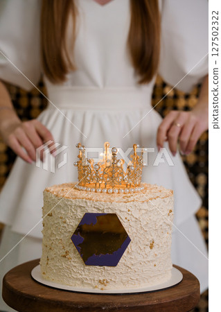 Elegant Woman With Crown Cake. Golden Birthday Celebration. White Dress. Textured Frosting. Glamorous Party Theme. Luxury Dessert. Festive Atmosphere Elegant Woman With Crown Cake. Golden Birthday Celebration. White Dress. Textured Frosting. Glamorous Party Theme. Luxury Dessert. Festive Atmosphere 127502322