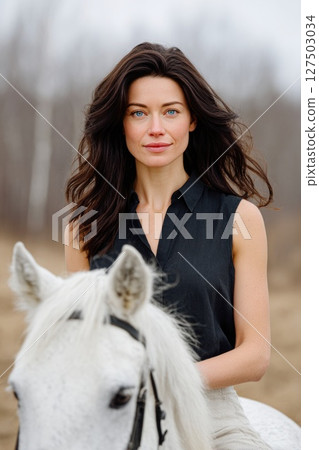 Confident Woman on White Horse in Nature 127503034