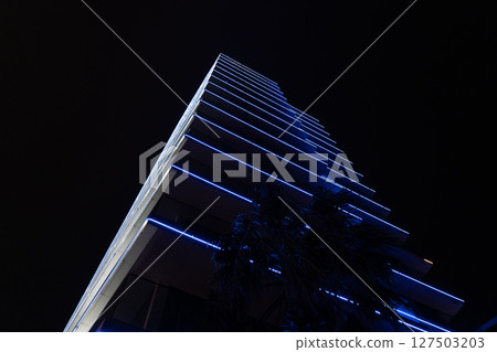 Blue illumination of a tall building at night 127503203