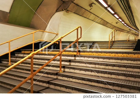 Stairs and yellow rail leading to underground train tunnel Stairs and yellow rail leading to underground train tunnel 127503381