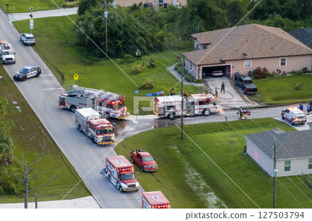 Firefighter trucks at fire alarm scene of suburban house. First responders at potential fire hazard at Florida home 127503794