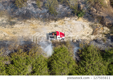 Dry season vegetation fire ignites Florida forest with firefighters combatting uncontrolled flames advancing through dense woods and smoke-filled skies Dry season vegetation fire ignites Florida forest with firefighters combatting uncontrolled flames advancing through dense woods and smoke-filled skies 127503811