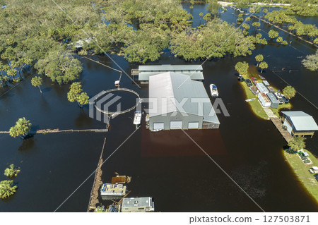 Consequences of natural disaster. Flooded industrial business warehouse by hurricane Ian rainfall in Florida rural area Consequences of natural disaster. Flooded industrial business warehouse by hurricane Ian rainfall in Florida rural area 127503871