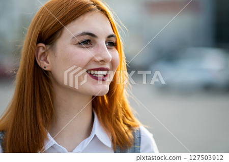 Closeup face portrait of a smiling teenage girl with red hair and clear eyes. Closeup face portrait of a smiling teenage girl with red hair and clear eyes. 127503912