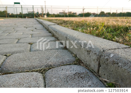 Close-up of slab stone paved path way at park or backyard. Walkway footpath road at house yard garden. Close-up of slab stone paved path way at park or backyard. Walkway footpath road at house yard garden. 127503914