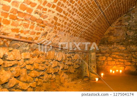 A view of old corridors lit by candles. Old cellar spaces lit by candles. The concept of romance and old times A view of old corridors lit by candles. Old cellar spaces lit by candles. The concept of romance and old times 127504174