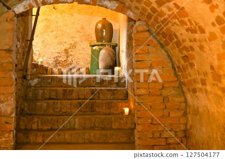 A view of an old cellar and old stoneware jars. Old basement stairs and stoneware jars for storing food. The concept of food storage and preservation in the past 127504177