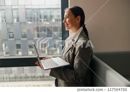 A Professional Woman Engaged with Her Laptop in a Stylish and Modern Office Environment A Professional Woman Engaged with Her Laptop in a Stylish and Modern Office Environment 127504788