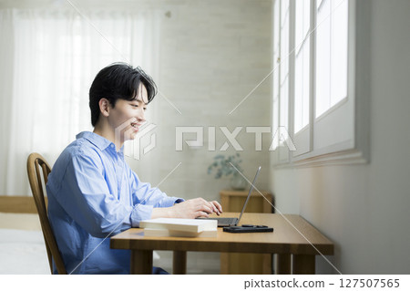 A young man using a computer 127507565