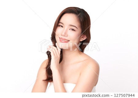 A beautiful young Asian woman with clean, fresh skin against a white background. Skincare, facial treatment, cosmetology, beauty, and spa. An elegant portrait of an Asian woman. 127507944