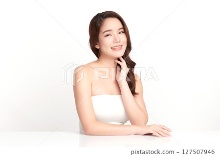 A beautiful young Asian woman with clean, fresh skin against a white background. Skincare, facial treatment, cosmetology, beauty, and spa. An elegant portrait of an Asian woman. 127507946