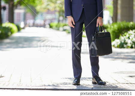 A young businessman in a suit standing in a business district 127508551