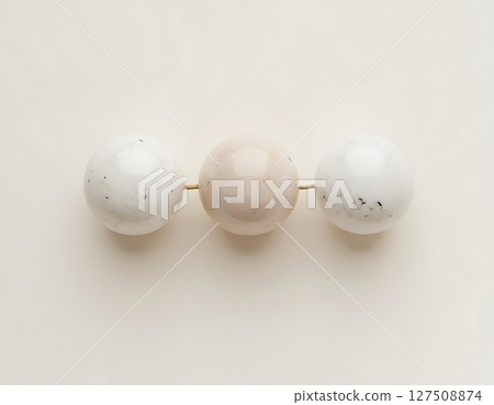 Three Speckled Beads on White Background 127508874