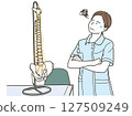 A female osteopathic therapist is worried next to a spinal model 127509249