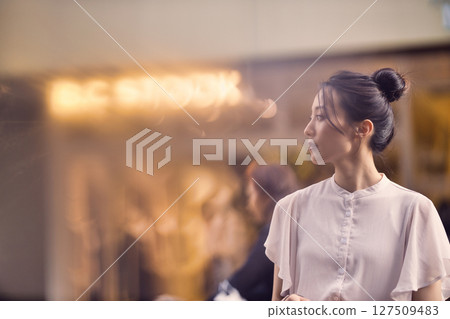 Woman walking through the city at dusk Woman walking through the city at dusk 127509483