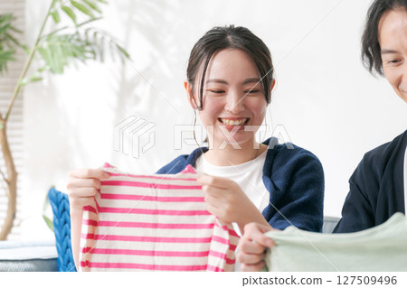 A couple putting away clothes 127509496