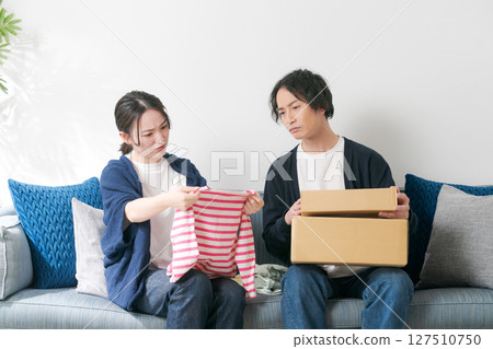 A couple organizing their clothes A couple organizing their clothes 127510750