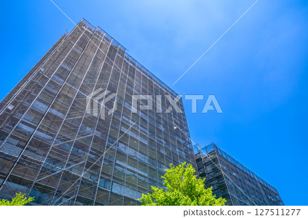 Yokohama cityscape in Japan. Apartment building repairs and inspections, scaffolding and protective nets. Satellite antennas outside the nets... 127511277