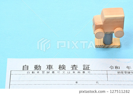 Image of an electronic vehicle inspection certificate and a car on a lift 127511282