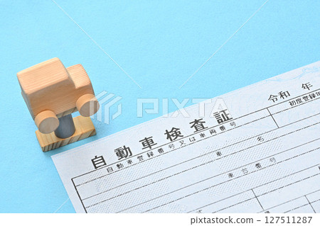 Image of an electronic vehicle inspection certificate and a car on a lift 127511287
