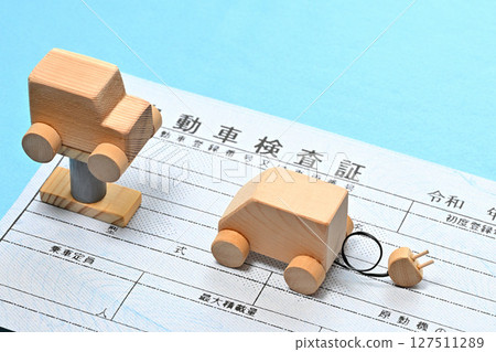 Image of an electronic vehicle inspection certificate and a car on a lift 127511289