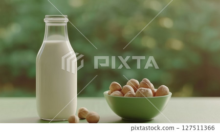 Hazelnut on bottle milk and hazelnuts on bowl copy space background 127511366