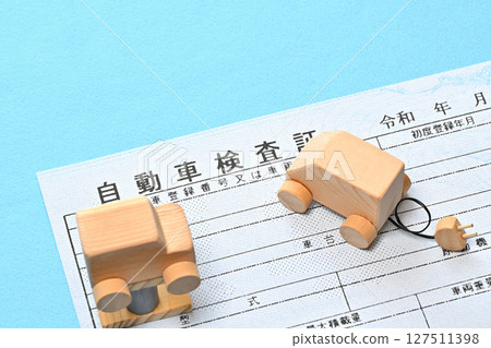 Image of an electronic vehicle inspection certificate and a car on a lift 127511398