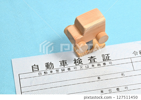 Image of an electronic vehicle inspection certificate and a car on a lift 127511450