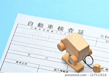 Image of an electronic vehicle inspection certificate and an electric vehicle on a lift 127511618