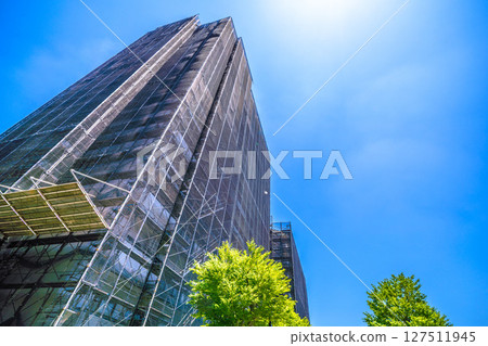 Yokohama cityscape in Japan. Apartment building repairs and inspections, scaffolding and protective nets. Satellite antennas outside the nets... 127511945