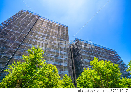 Yokohama cityscape in Japan. Apartment building repairs and inspections, scaffolding and protective nets. Satellite antennas outside the nets... 127511947