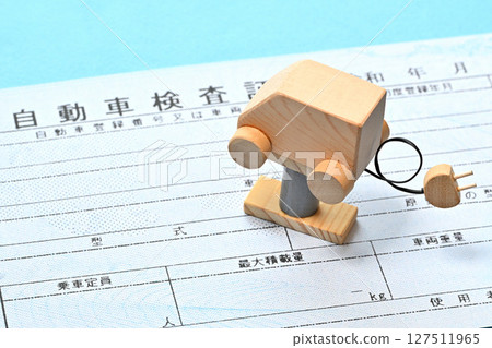 Image of an electronic vehicle inspection certificate and an electric vehicle on a lift 127511965