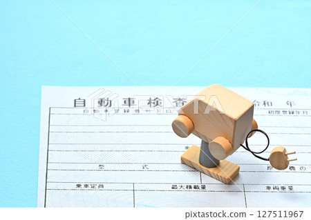 Image of an electronic vehicle inspection certificate and an electric vehicle on a lift 127511967
