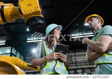 Robotic engineer team automatic holding tablet checking Plan system of automation robot arms machine in factory. Service programming machinery welding robots in production at factory industry. 127512167