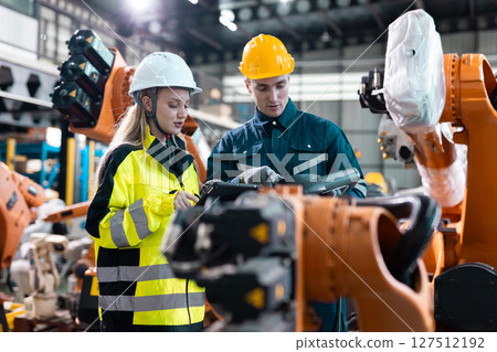 Robotic engineer team automatic checking Plan system of automation robot arms machine in factory. Programming machinery welding robots in production at factory industry. Robotic engineer team automatic checking Plan system of automation robot arms machine in factory. Programming machinery welding robots in production at factory industry. 127512192