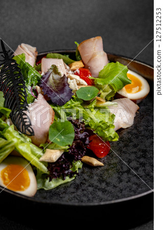 Plate of Fresh Green Salad with turkey ham, mozzarella and tomato isolated on white background Plate of Fresh Green Salad with turkey ham, mozzarella and tomato isolated on white background 127512253
