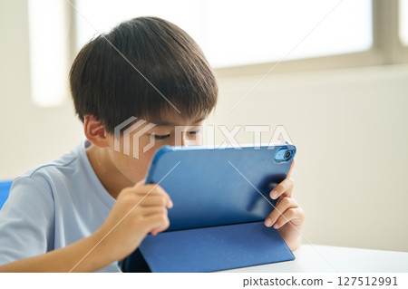 Boy with eyes too close to monitor 127512991